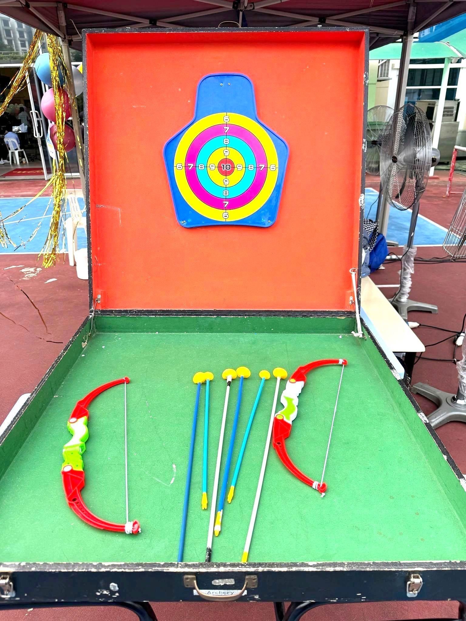 Carnival Games Singapore: A Family-Day Stamp Card Plan 13 Tabletop archery carnival game with a colourful target, toy bows and suction arrows