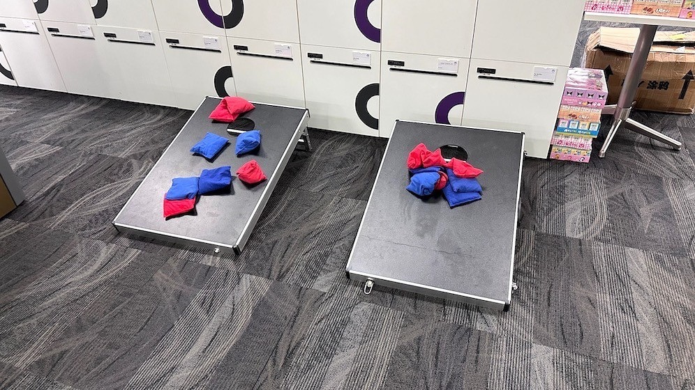 Carnival Games Singapore: A Family-Day Stamp Card Plan 7 Two cornhole carnival game boards with red and blue beanbags at a Singapore indoor venue