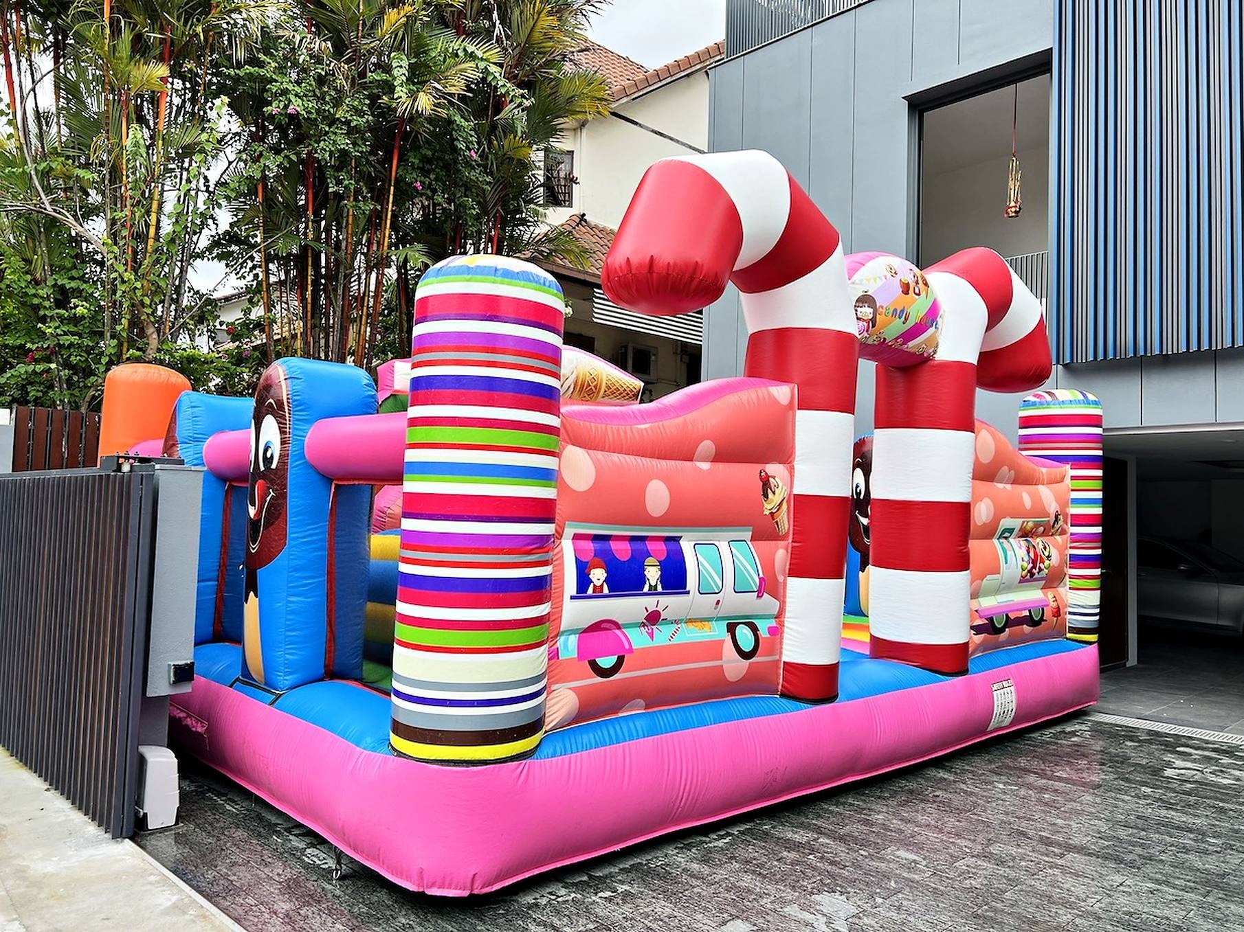Bouncy Castle Rental: 6 Smart Ways to Choose for Your Event 12 Pink candy themed bouncy castle beside a building