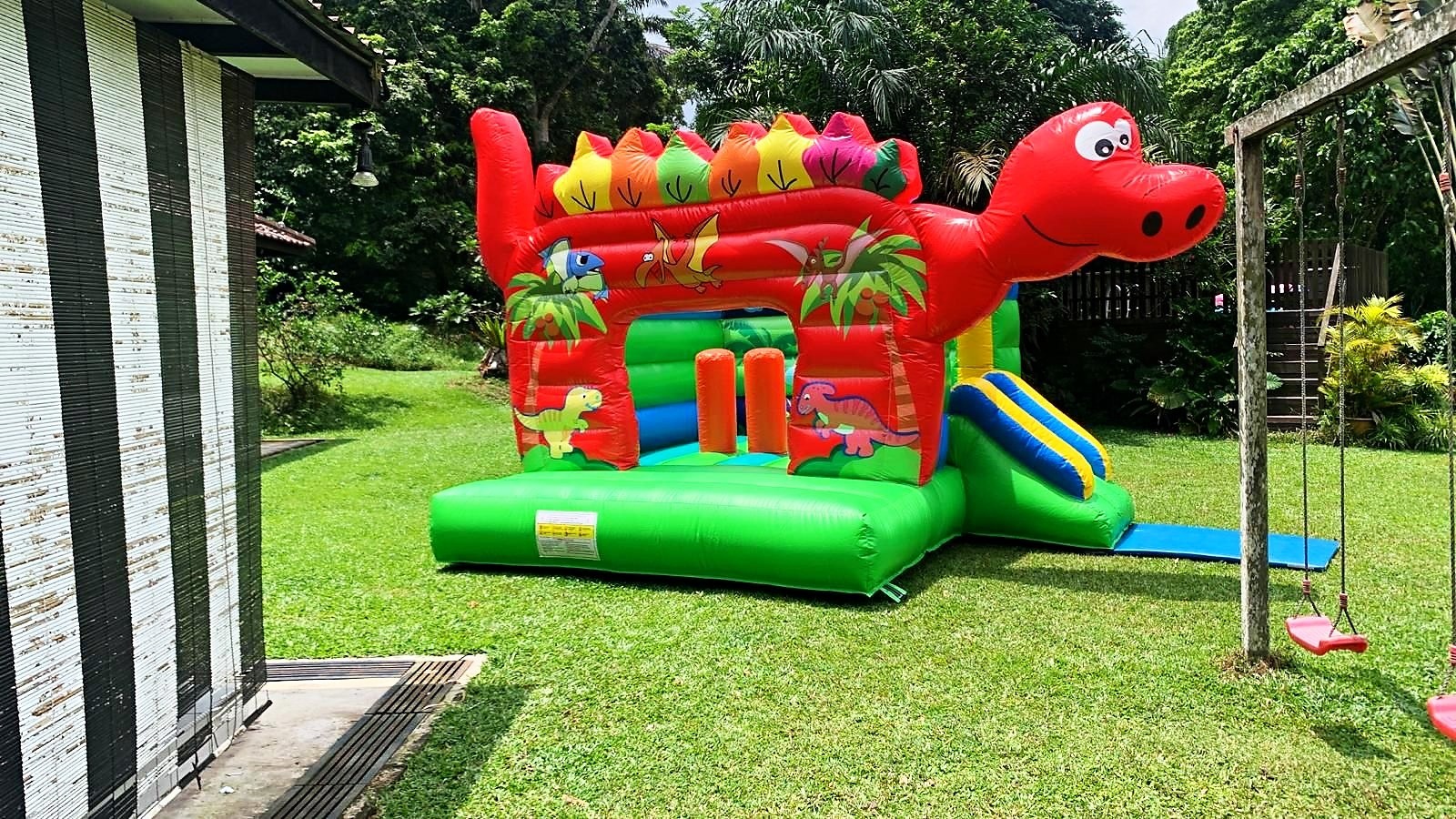 Bouncy Castle Rental: 6 Smart Ways to Choose for Your Event 5 Red dinosaur bouncy castle with slide in a garden