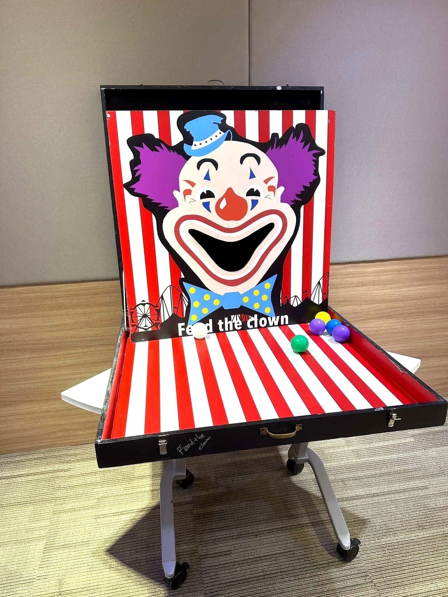 Carnival Games Singapore: A Family-Day Stamp Card Plan 11 Feed the Clown carnival ball-toss game with a striped board and colourful balls in Singapore