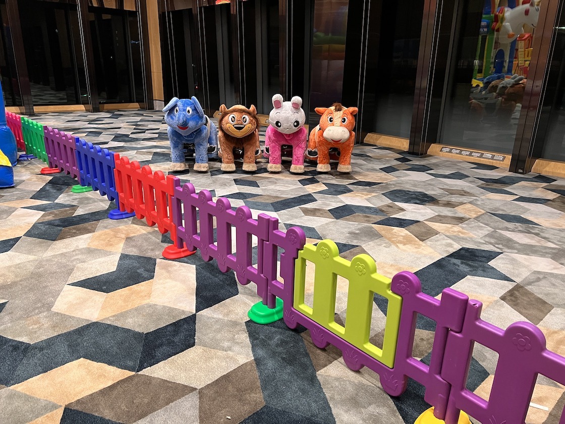 Carnival Rides for a Family Day: Trains, Animal Rides and Go-Karts 12 Animal rides behind colourful fencing in an indoor venue