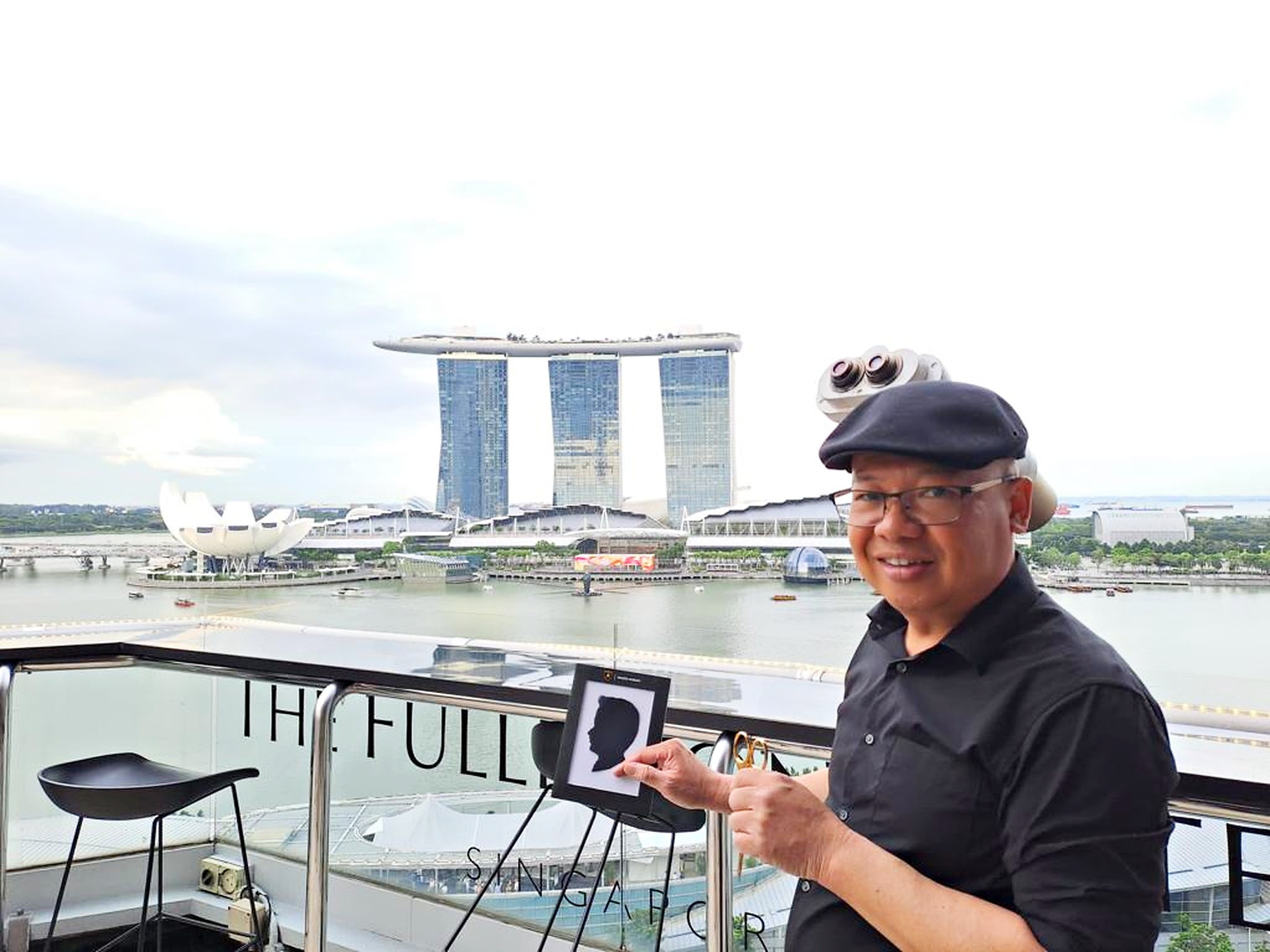 Creative Fringe Activities: 6 Smart Ways to Plan a Personalised Event 3 Silhouette cutting artist holding a paper portrait beside Marina Bay