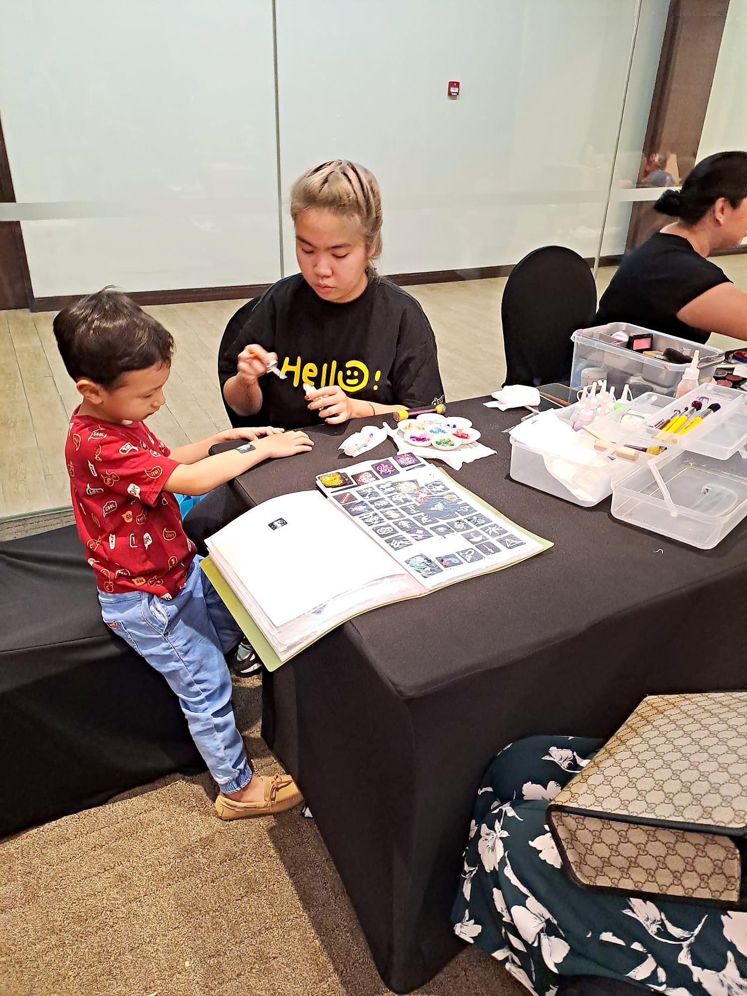 Creative Fringe Activities: 6 Smart Ways to Plan a Personalised Event 4 Temporary tattoo artist applying a design for a child