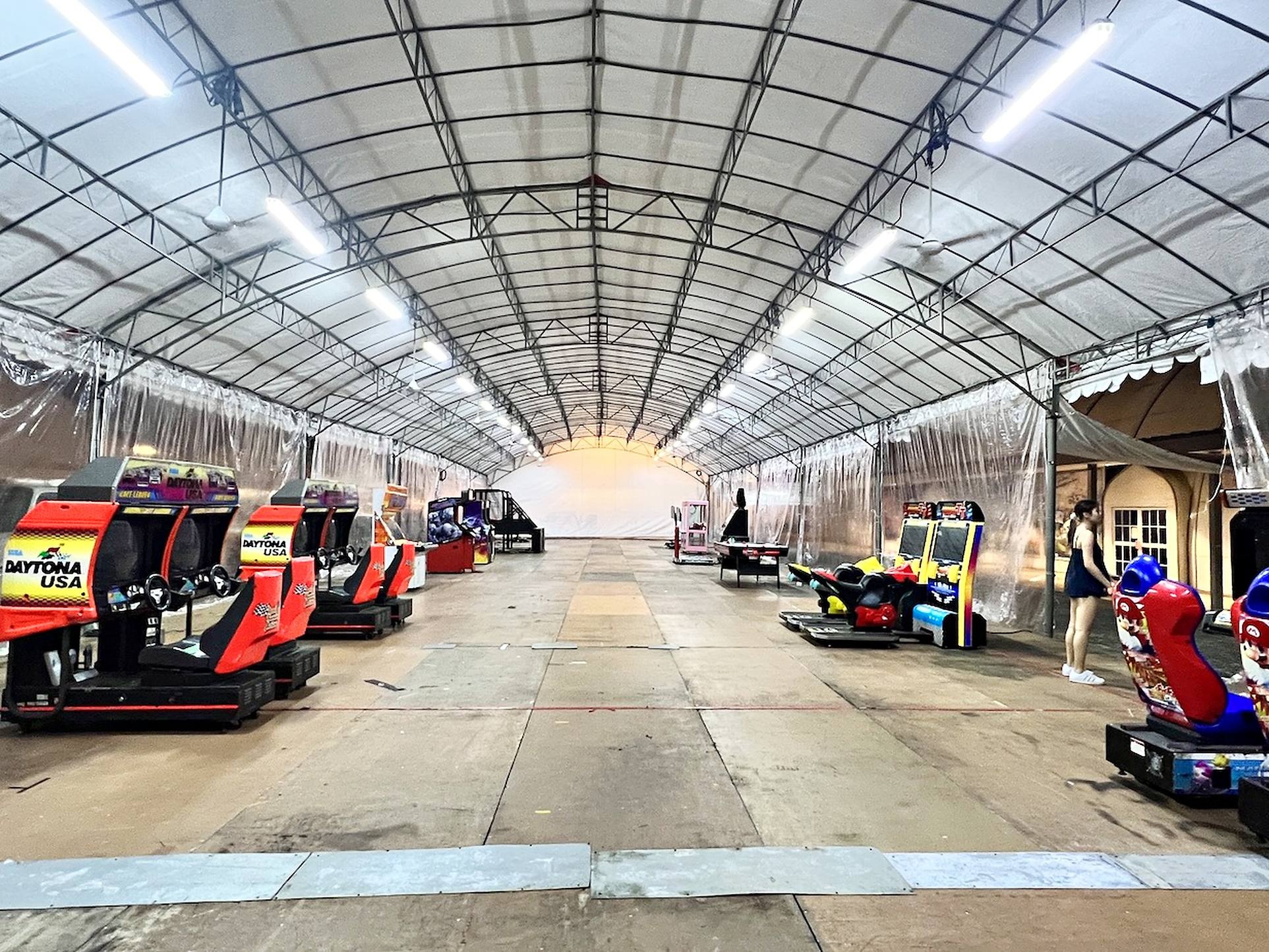 Arcade Party Ideas: From a Neon Games Room to a Racing Lounge 6 Racing arcade machines arranged inside a sheltered event tent