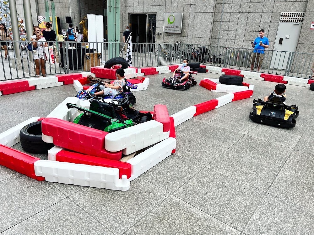 Carnival Rides for a Family Day: Trains, Animal Rides and Go-Karts 8 Children driving small go-karts inside a marked course