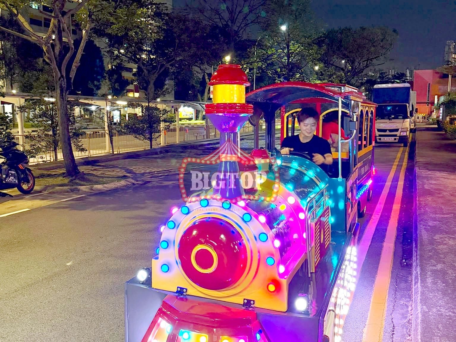 Carnival Rides for a Family Day: Trains, Animal Rides and Go-Karts 7 Illuminated trackless train at an evening event