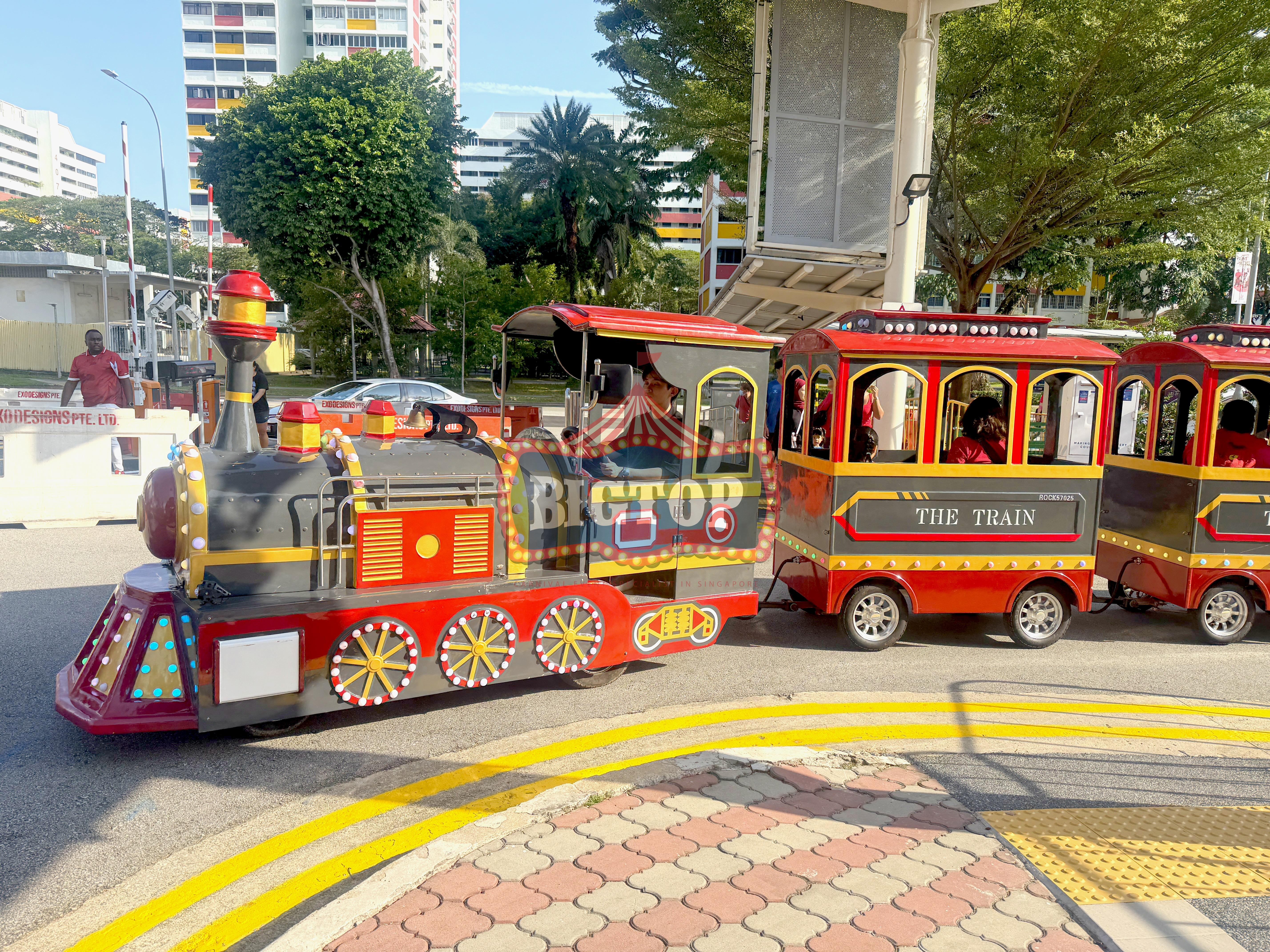 Carnival Rides for a Family Day: Trains, Animal Rides and Go-Karts 2 Carnival Rides featuring a red and gold trackless train at an outdoor event